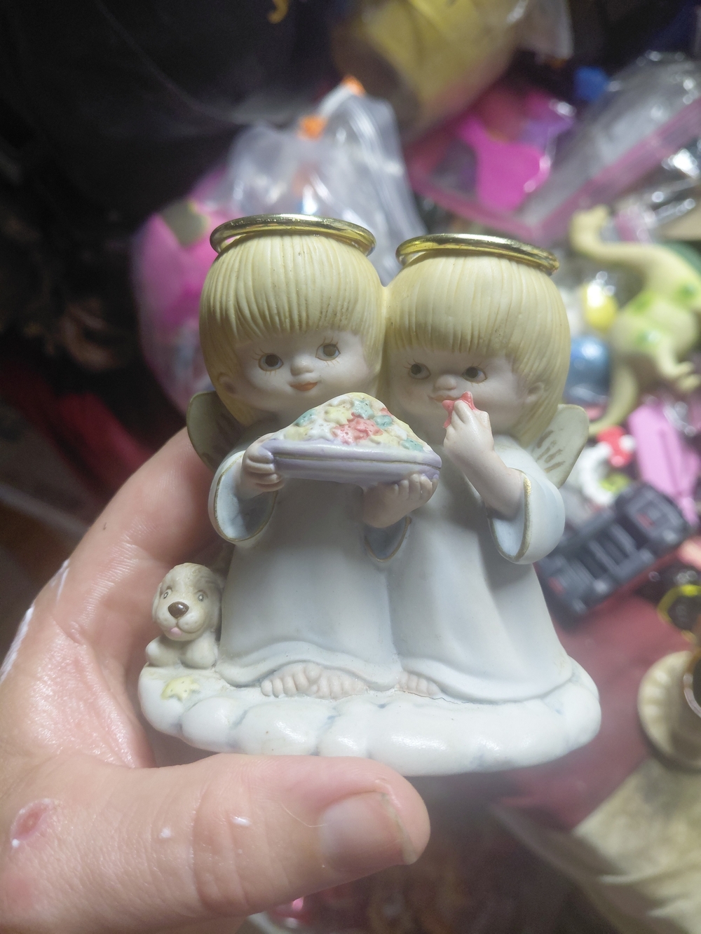 shows a vintage ceramic or porcelain figurine featuring two blonde-haired cherub